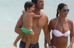 Grávida, Juliana Paes desfila barrigão de biquíni na praia com o marido e filho