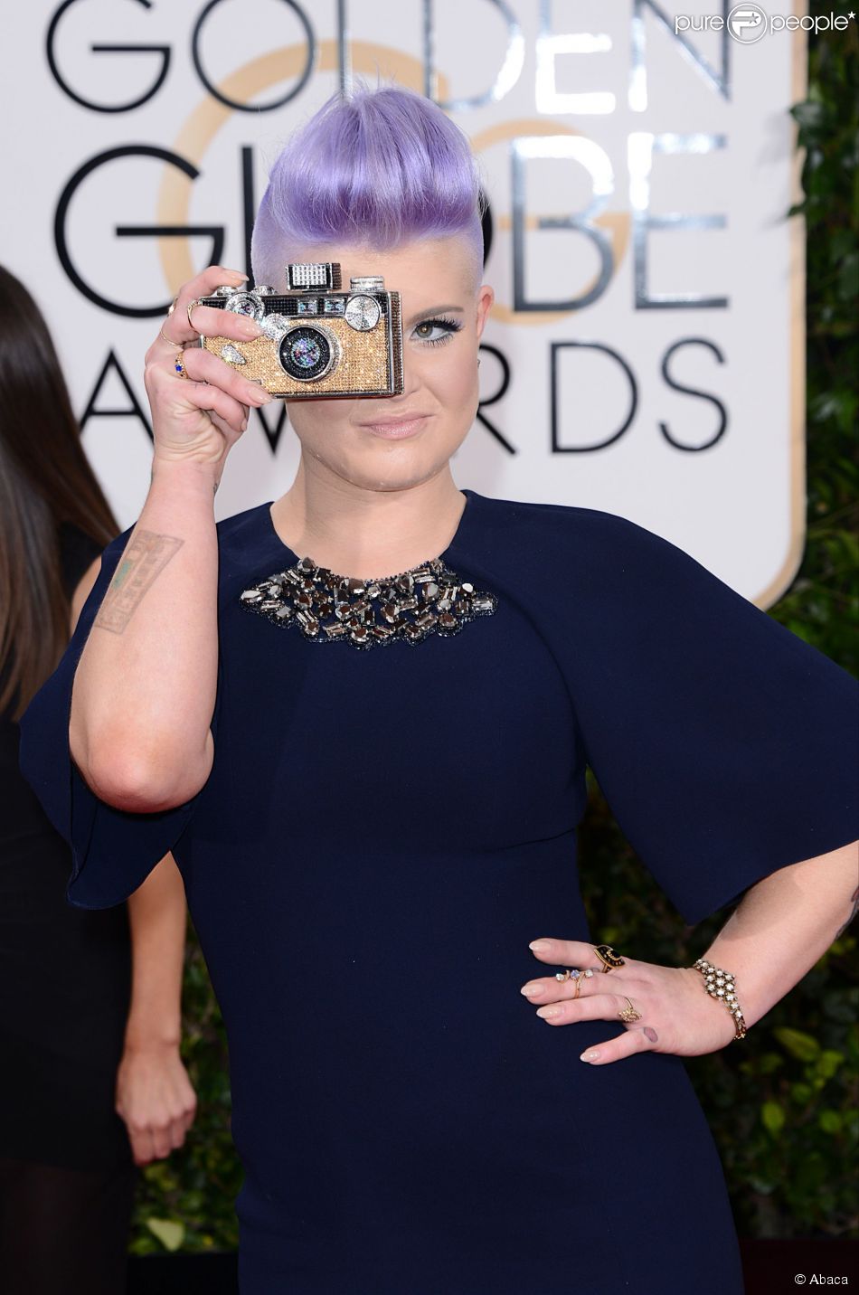 Globo de Ouro 2015: Kelly Osbourne brinca com a bolsa em forma de c&acirc;mera fotogr&aacute;fica ao posar no tapete vermelho