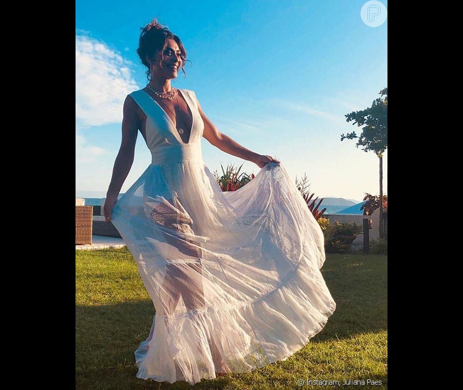 O vestido longo branco com decote mega profundo babados na barra foi a escolha de Juliana Paes para o look do RÃ©veillon 2019