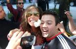 Steven Tyler dá autógrafos, ganha presente e beija fã na despedida do Rio