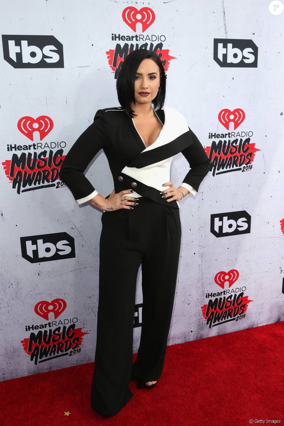 Demi Lovato também optou por macacão no iHeartRadio Music Awards. A aposta da cantora foi em um modelo preto e branco Alexander McQueen