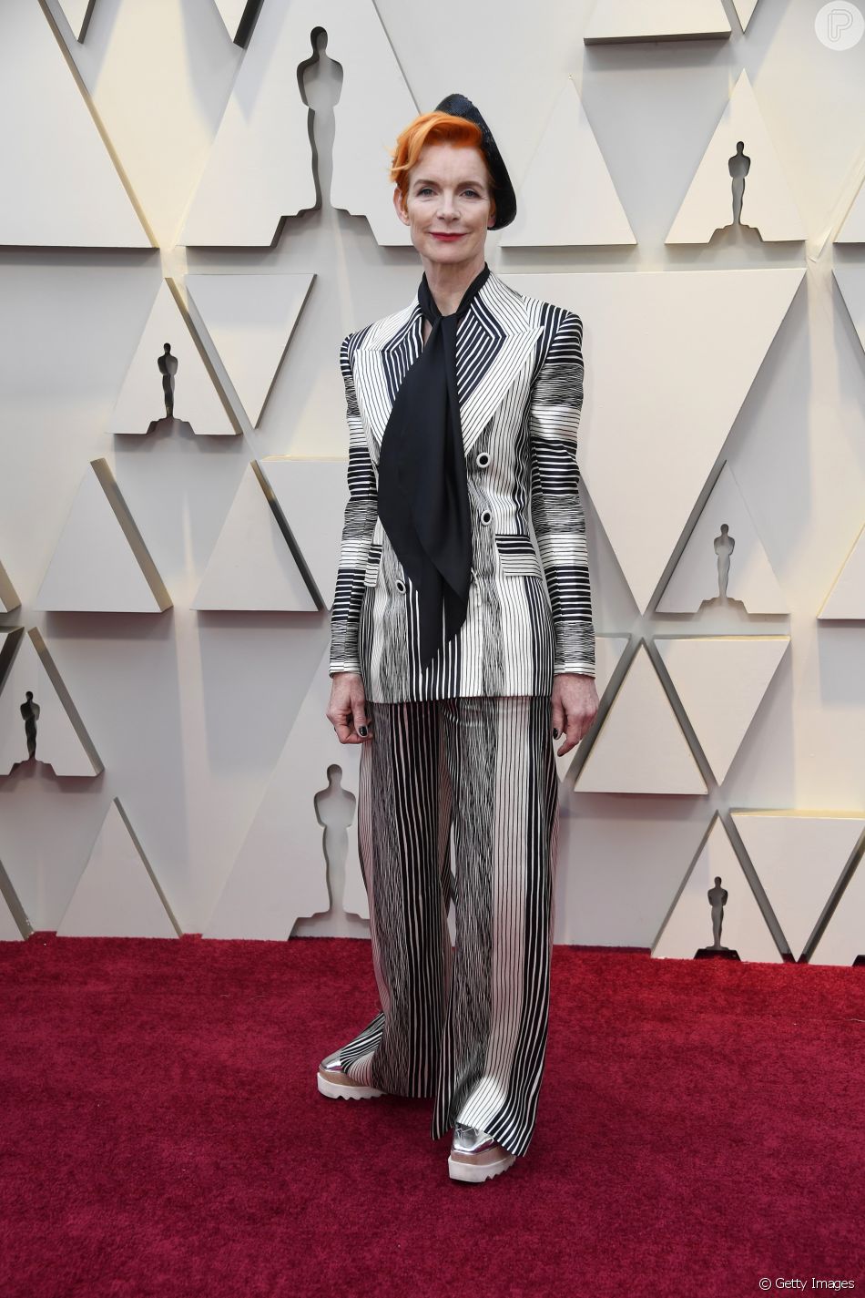 A figurinista Sandy Powell apostou em calÃ§a e terno listrado para a noite de gala do Oscar 2019