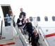 Madonna desce as escadas do avião acompanhada por seus filhos