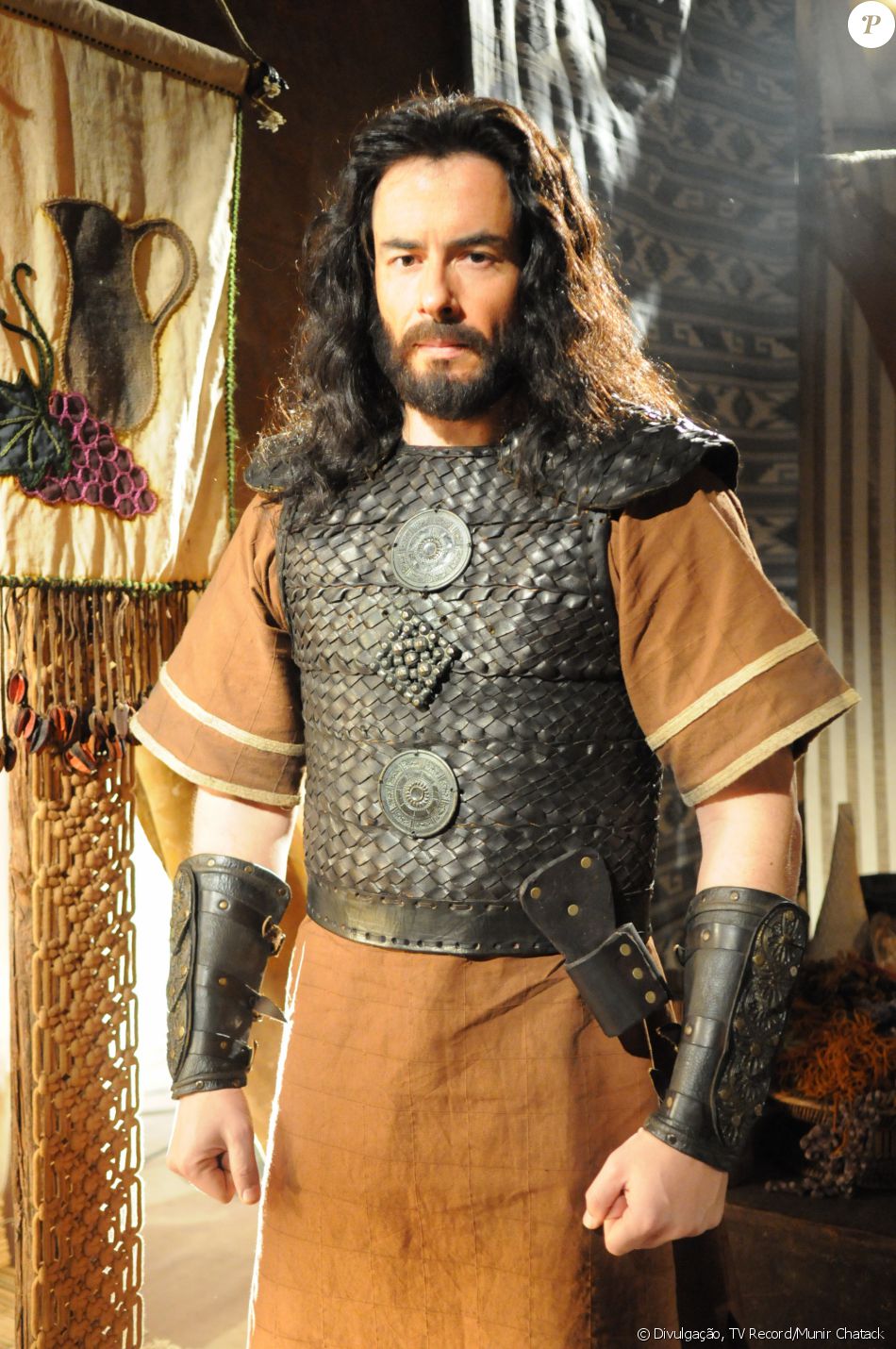 Eliéber (Felipe Folgosi) é quem ensina a irmã de criação, Aruna (Thais Melchior), a usar arco e flecha, na novela 'A Terra Prometida'
