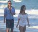 Nathália Dill e o namorado caminham juntos na praia