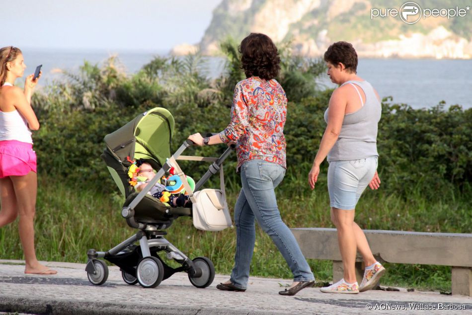Larissa Maciel empurra o carrinho da filha em passeio pela orla da Barra da Tijuca, no Rio