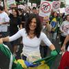 Helena Ranaldi leva a bandeira do Brasil durante protesto