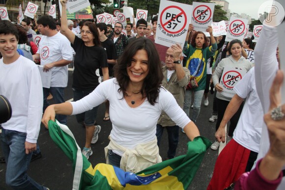 Helena Ranaldi leva a bandeira do Brasil durante protesto