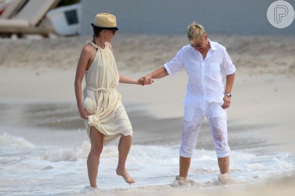 Ellen DeGeneres e Portia de Rossi caminham de mãos dadas pela praia