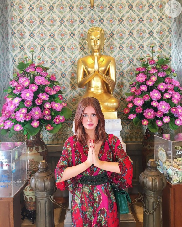 Para visitar um templo budista na Tailândia, Marina Ruy Barbosa usa vestido estampado Tigresse de R$ 945 combinado a cinto em camurça verde com ilhós e tiras transpassando ao longo da peça, e fecho com dois pinos em ouro envelhecido e 4 furos de regulagem, da marca Iorane, vendido a R$ 244,50