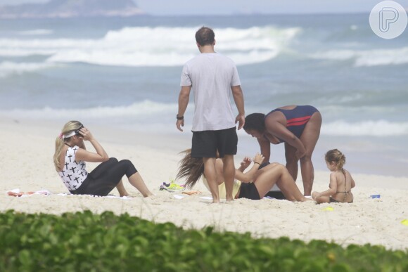 Flávia Alessandra faz abdominais com a filha Giulia na praia da Barra da Tijuca