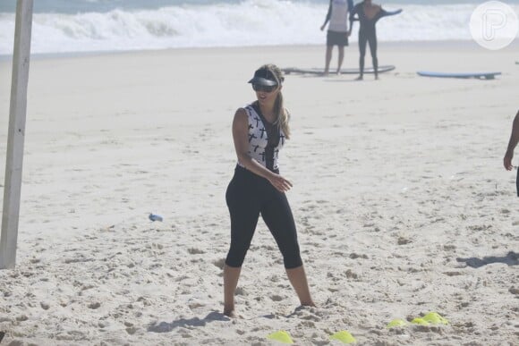 Flavia se prepara antes de iniciar mais um exercício passado pelo professor na praia da Barra da Tijuca