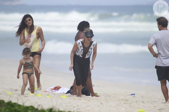 Olívia segue a mãe durante os exercícios na areia