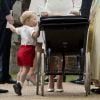 Fofo! Príncipe George ficou na pontinha dos pés para olhar a irmã, princesa Charlotte, dentro do carrinho ao saírem de igreja em Londres, no dia 5 de julho de 2015