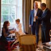 Enquanto príncipe William conversava com Barack Obama, príncipe George brinca em seu cavalinho de madeira, em 22 de abril de 2016