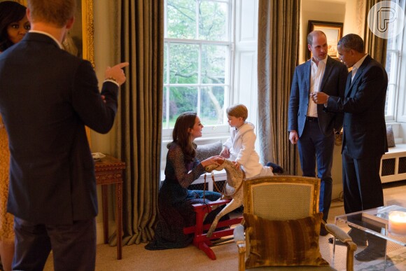 Enquanto príncipe William conversava com Barack Obama, príncipe George brinca em seu cavalinho de madeira, em 22 de abril de 2016