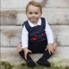 Com um sorriso fofo, príncipe George sentou no pátio do Palácio Kensington, em Londres, para sua foto oficial de Natal, em novembro de 2014