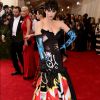 Katy Perry foi ao Met Gala 2015 usando vestido preto com estampas imitando pichações da grife Moschino. Sua bolsa era uma imitação de latinha de spray