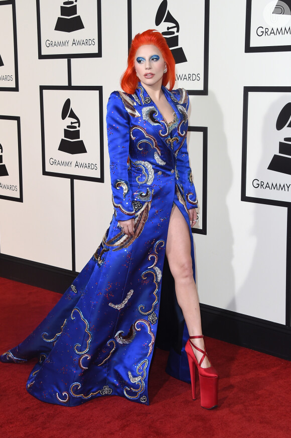 Exótica! Com os cabelos na cor laranja, Lady Gaga usou vestido azul combinando com a maquiagem. Completou o visual com sapatos vermelhos superaltos