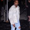 Kanye West foi ao Met Gala com visual diferente: calça destroyed e jaqueta toda metalizada. O cantor ainda usou lentes de contato na cor azul