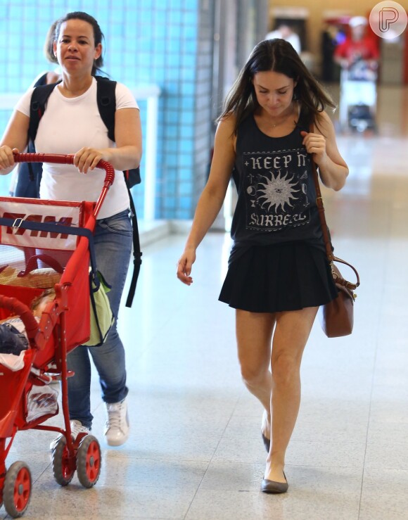 Gabriela Duarte caminha no aeroporto com as pernas de fora