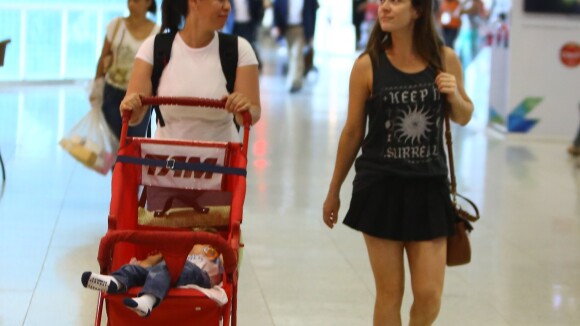 Gabriela Duarte, com as pernas de fora, é flagrada no aeroporto com o filho