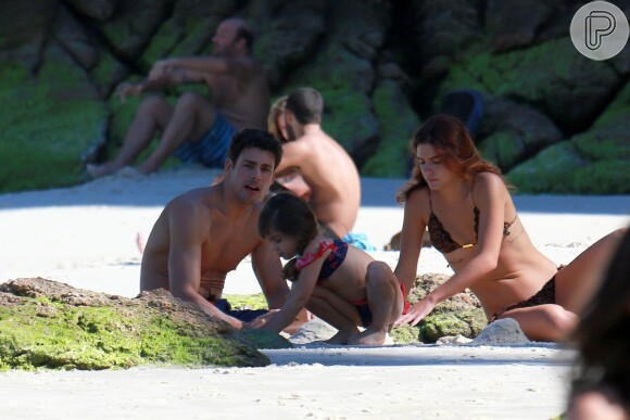 Mariana Goldfarb se diverte com Cauã Reymond e a enteada Sofia, de quatro anos, em praia no Rio de Janeiro