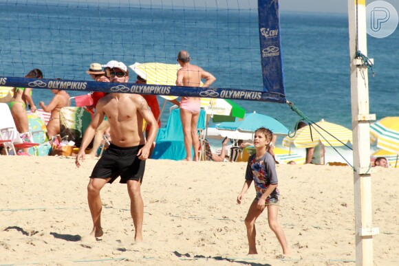 Hilbert joga volêi de praia com um dos filhos gêmeos