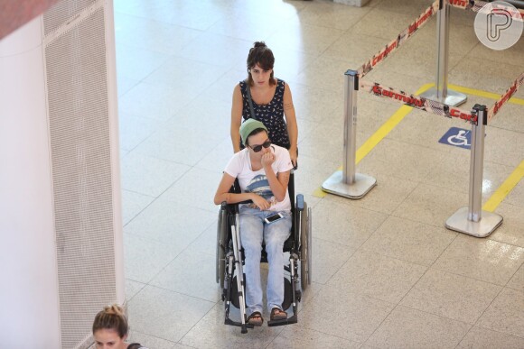 Maria Gadú recebe a ajuda da mulher, Lua Leça, em aeroporto do Rio