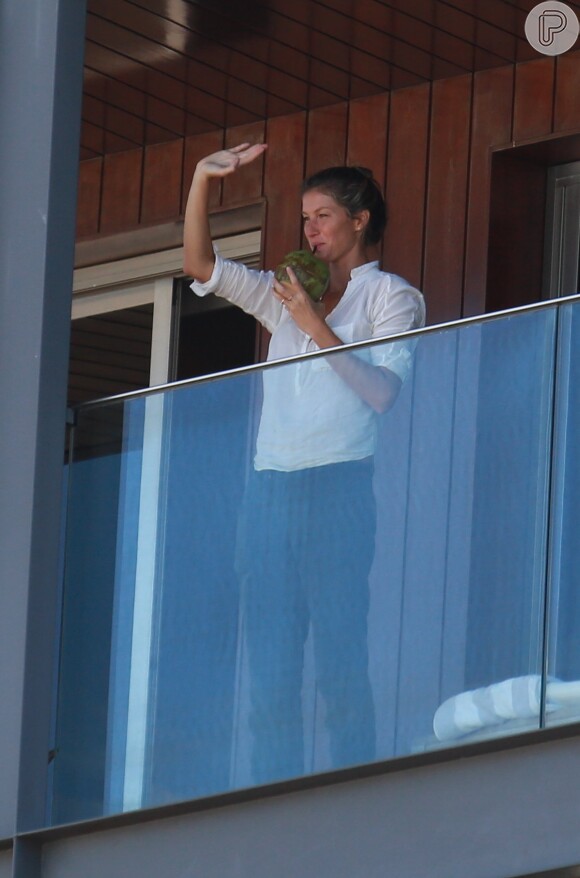Gisele Bündchen aproveitou para tomar água de coco e acenou para os fãs que a viram no terraço do hotel