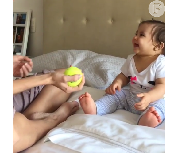No vídeo, Deborah lança uma bola de tênis para o alto a arranca risadas da filha, Maria Flor