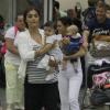 Juliana Paes é fotografada no aeroporto do Galeão, no Rio, com o filho Antônio nos braços