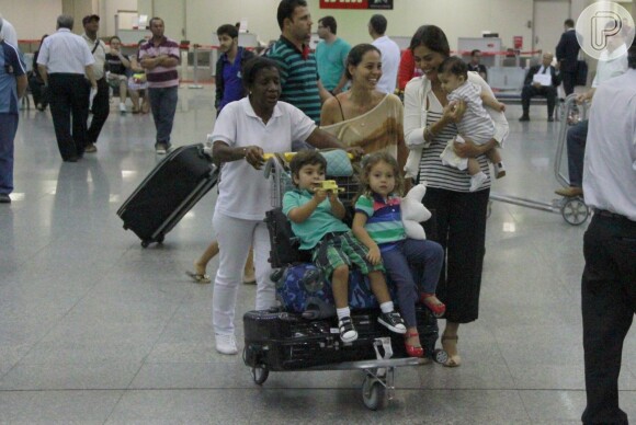 Juliana Paes desembarca sorridente com a família