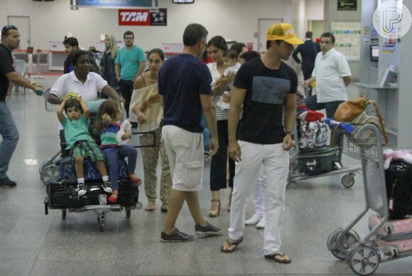 Juliana Paes é fotografada caminhando com a família no aeroporto do Galeão, no Rio