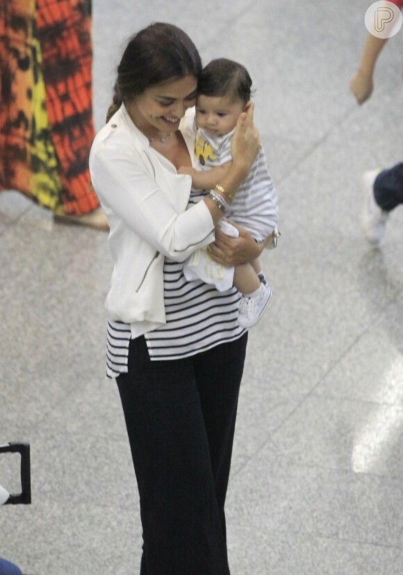 Juliana Paes, sorridente, carrega o filho caçula no colo. Antônio está com 4 meses