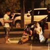 Daniel Rocha troca telefones com mulheres sentadas na calçada