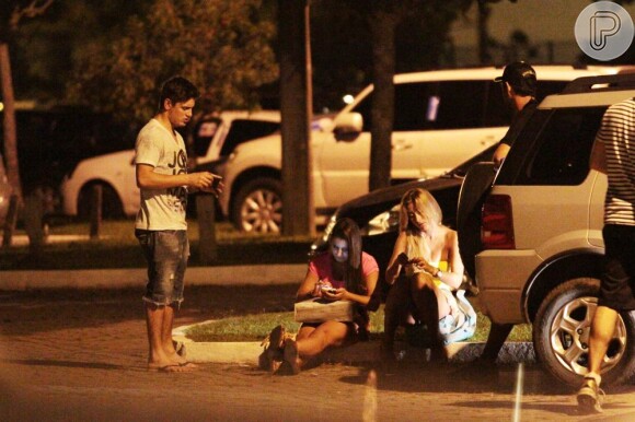 Daniel Rocha troca telefones com mulheres sentadas na calçada