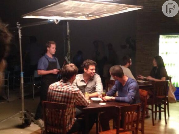No set, Cauã Reymond simula estar em um bar com amigos