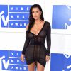 Adepta do wet look, Kim Kardashian escolheu o vestido decotado assinado por Galliano, que deixava a incerteza sobre a presença de lingerie no look