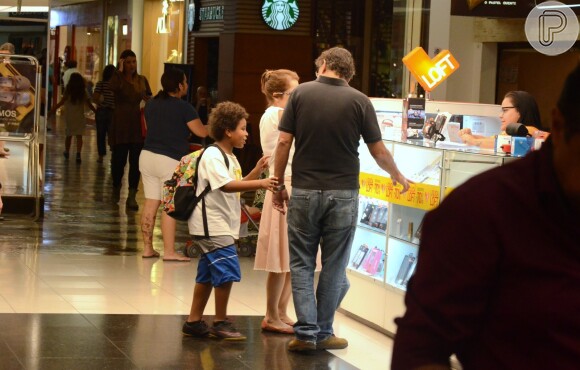 Drica Moraes, o filho, Matheus, e o marido vêem loja de acessórios para celular