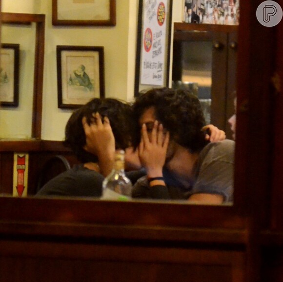 Gabriel Leone e a namorada, Carla Salle, se beijam em restaurante