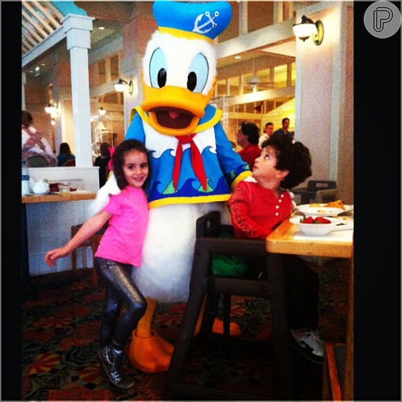 Donatella, de 4 anos, e Stefano, 2, filhos de Marcos Mion, tiram foto com o Pato Donald em restaurante da Disney