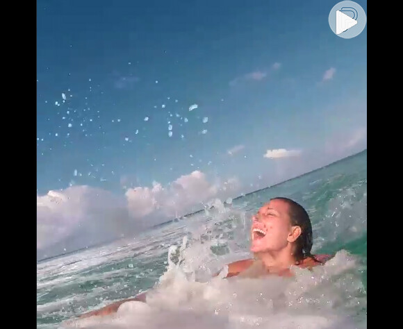 Depois de surfar, Maya Gabeira se joga no mar e abre um sorriso de alegria