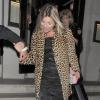 Kate Moss deixa restaurante se apoiando em amigo