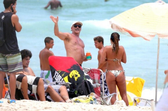 Oscar Magrini, o coronel Nunes de 'Salve Jorge', curte praia com duas amigas e acena para paparazzo, em Ipanema, na zona sul do Rio de Janeiro, em 8 de janeiro de 2013