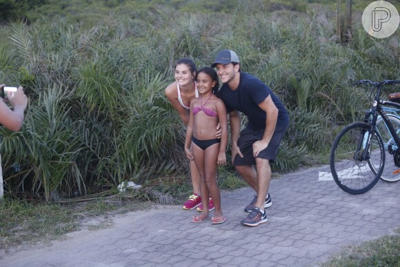 Camila Queiroz e Klebber Toledo posam com fã mirim durante passeio na Barra