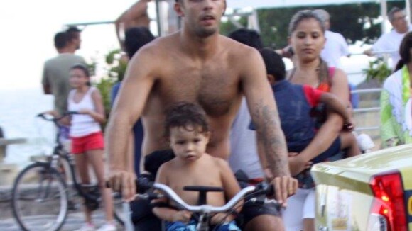 Pedro Scooby anda de bicicleta com o filho Dom na praia do Leblon, no Rio