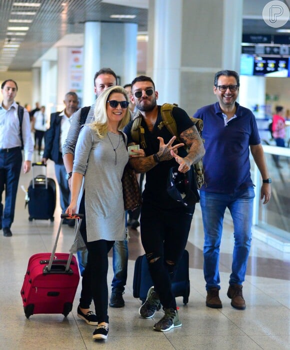 Lucas Lucco brinca com paparazzo ao embarcar com os pais, Karina e Paulo, no aeroporto