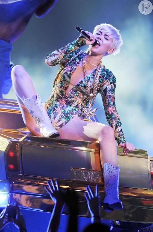 Miley Cyrus sensualiza em cima de um capô de um carro na Bangerz Tour