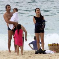 Cláudia Abreu passa sábado em família na praia usando maiô retrô